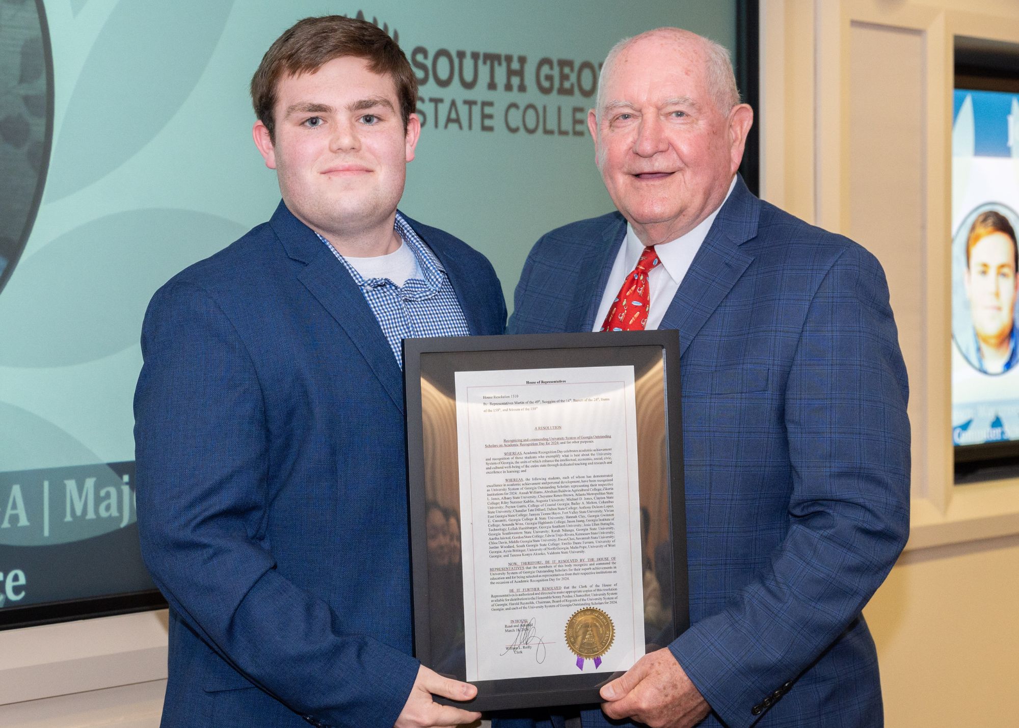Jordan Woodard with Chancellor Sonny Perdue with commendation letter